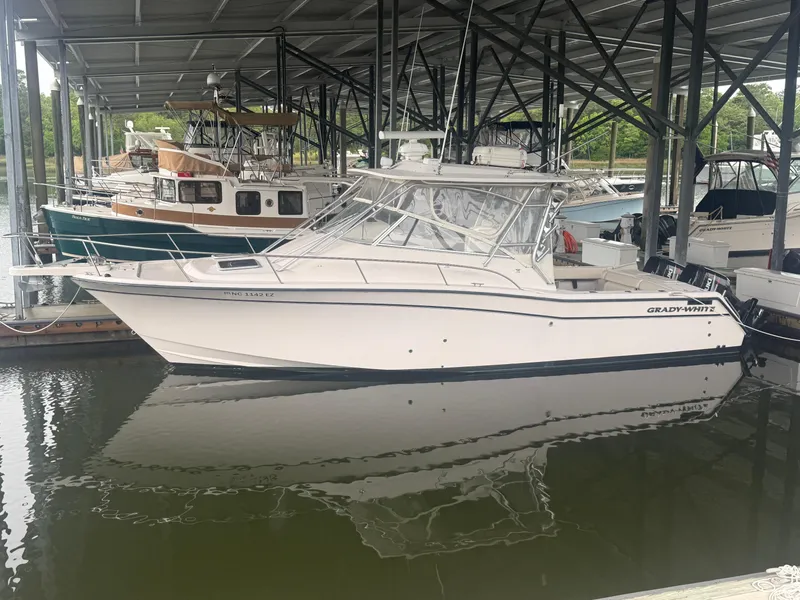 Slide: The Image of 2002 Grady-White Express 330 boat docked in a marina under a covered structure. - 3