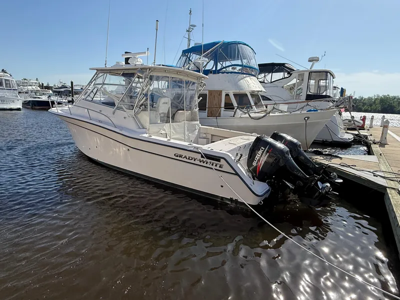 Slide: The Image of 2002 Grady-White Express 330 boat docked at marina with outboard motors. - 32