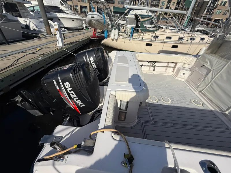 Slide: The Image of 2002 Grady-White Express 330 boat with twin Suzuki outboard motors docked at a marina. - 34