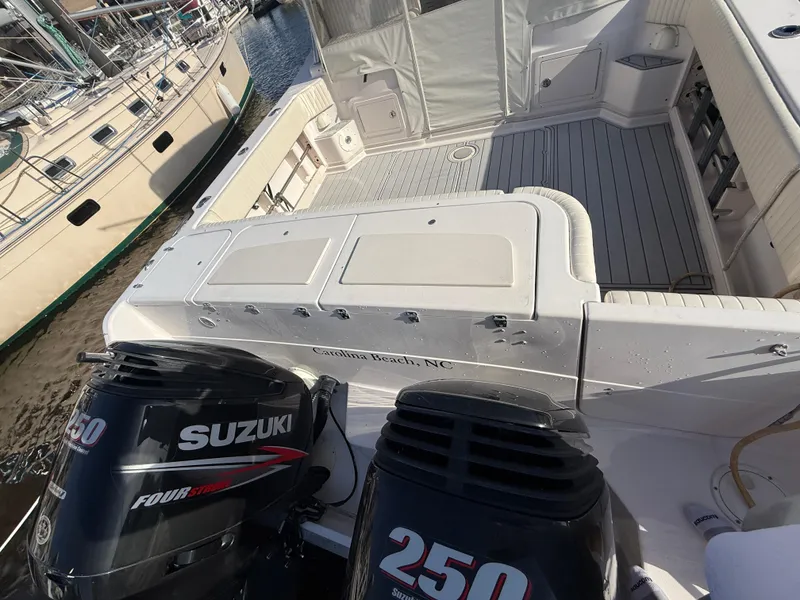 Slide: The Image of 2002 Grady-White Express 330 boat with Suzuki 250 engines, docked at a marina. - 37