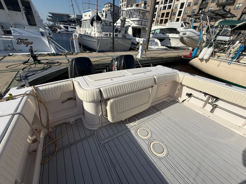 Slide: The Image of 2002 Grady-White Express 330 boat docked, showcasing spacious deck and marina background. - 39