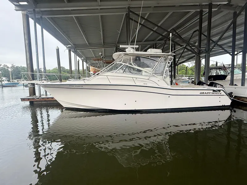 Slide: The Image of 2002 Grady-White Express 330 boat docked under a covered marina. - 4