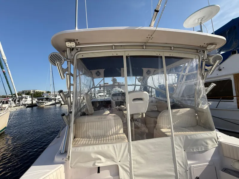 Slide: The Image of 2002 Grady-White Express 330 boat docked at marina, featuring enclosed cockpit. - 42