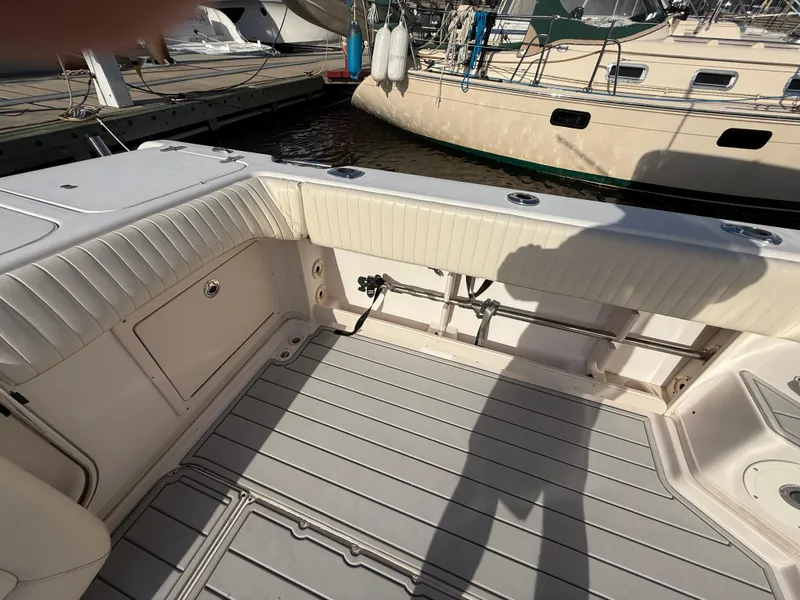 Slide: The Image of 2002 Grady-White Express 330 boat interior with cushioned seating and docked sailboats. - 47