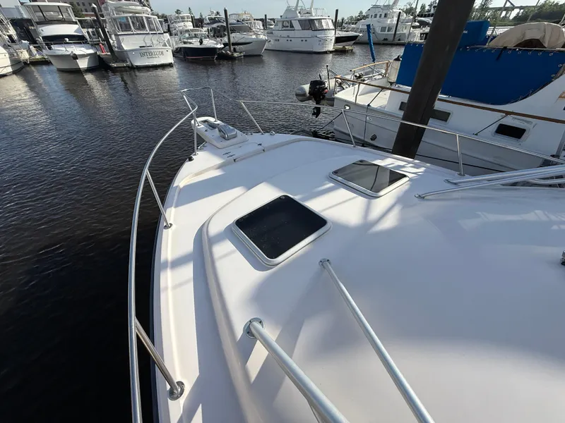 Slide: The Image of 2002 Grady-White Express 330 boat docked in a marina, surrounded by other vessels. - 48