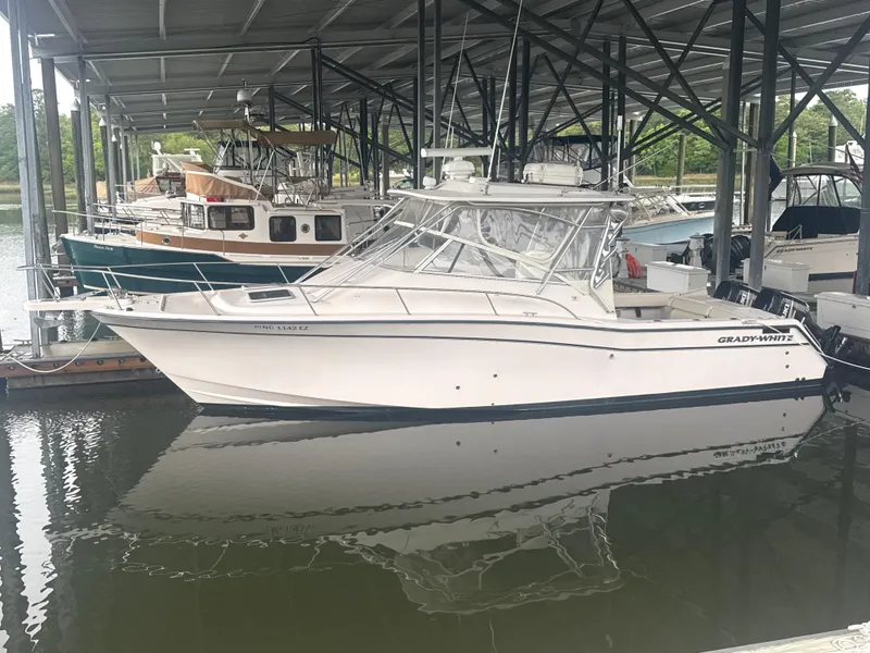 Slide: The Image of 2002 Grady-White Express 330 boat docked in a marina under a covered structure. - 5