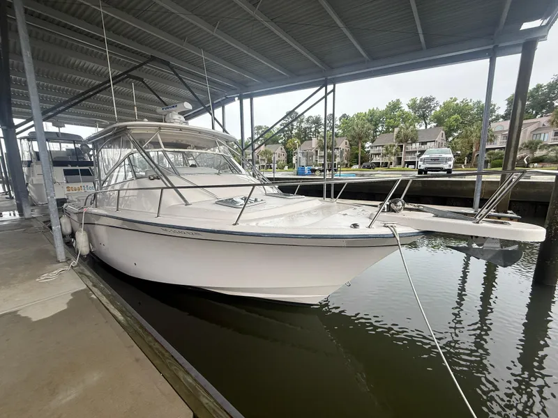 Slide: The Image of 2002 Grady-White Express 330 boat docked under a covered marina. - 6
