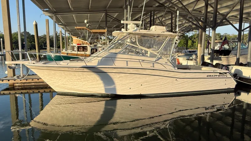 Slide: The Image of 2002 Grady-White Express 330 boat docked under a covered marina. - 7