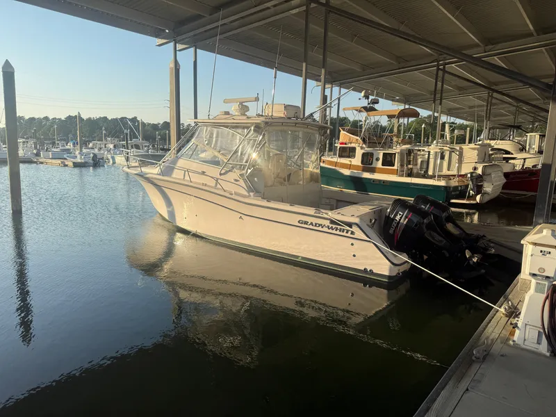 Slide: The Image of 2002 Grady-White Express 330 boat docked in a marina under a covered shelter. - 8