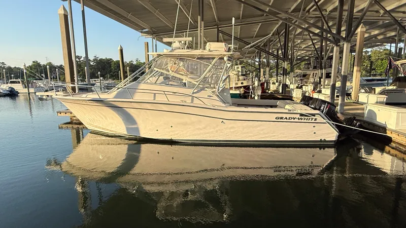 Slide: The Image of 2002 Grady-White Express 330 boat docked in marina under covered shelter. - 9