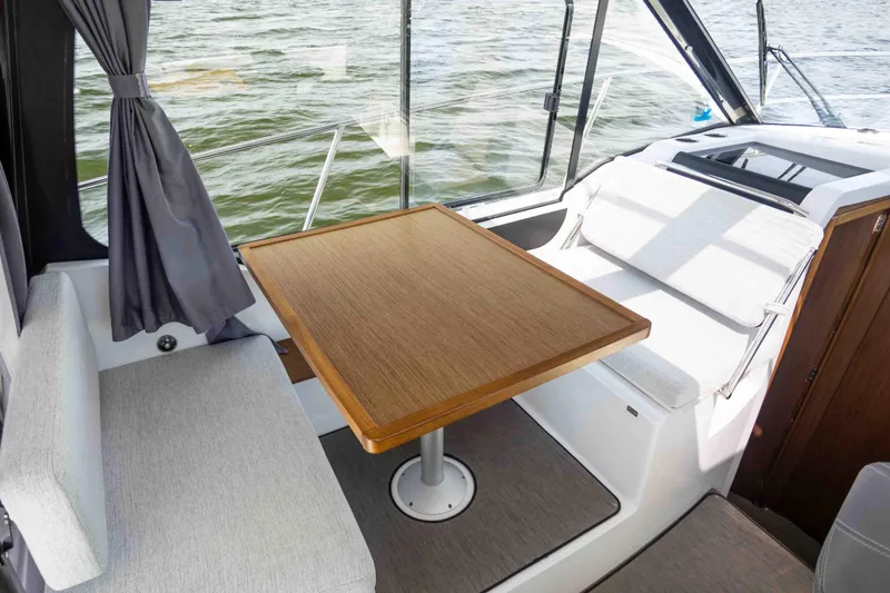 Slide: The Image of Interior of 2022 Jeanneau NC Weekender 895, featuring a cozy seating area with a wooden table. - 10