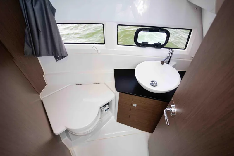 Slide: The Image of 2022 Jeanneau NC Weekender 895 bathroom with modern sink, toilet, and window view. - 18