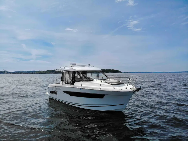Slide: The Image of 2022 Jeanneau NC Weekender 895 boat on calm water under a clear sky. - 2