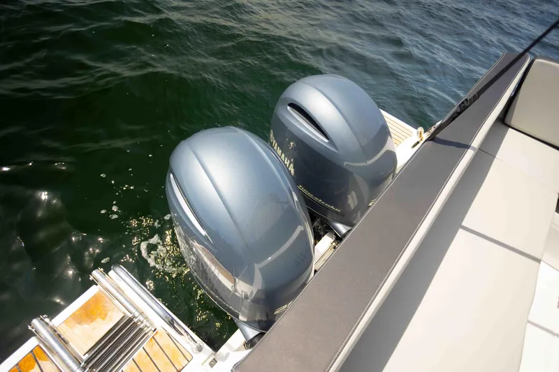 Slide: The Image of 2022 Jeanneau NC Weekender 895 with dual outboard motors on water. - 21