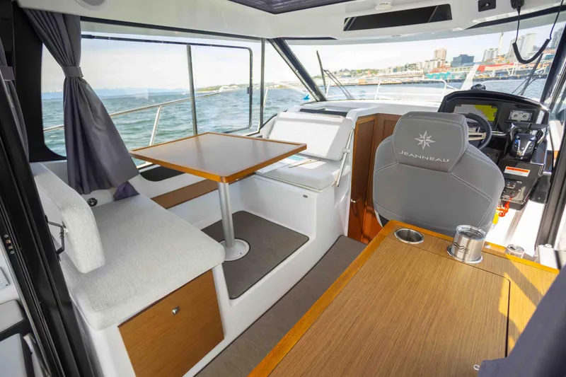 Slide: The Image of Interior of 2022 Jeanneau NC Weekender 895, featuring seating, table, and helm station. - 22