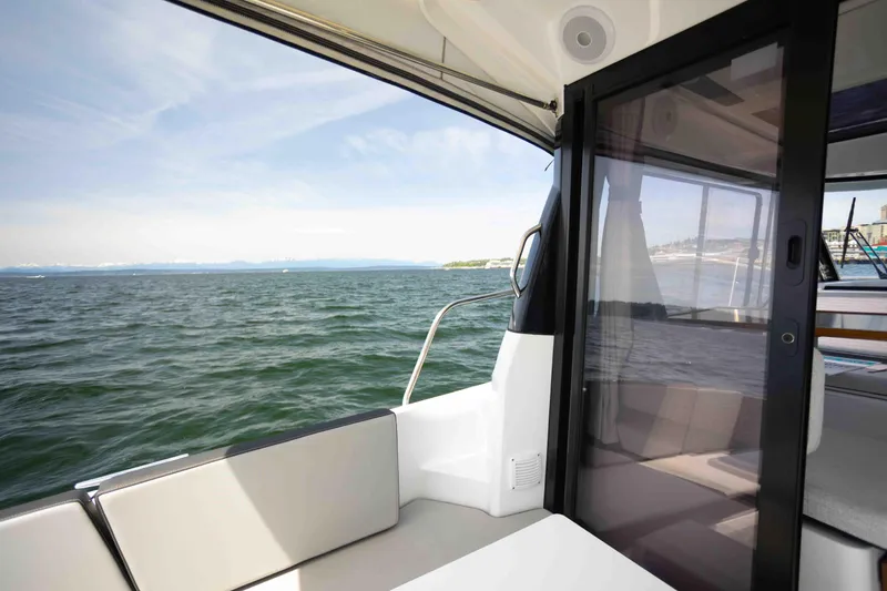 Slide: The Image of 2022 Jeanneau NC Weekender 895, interior view with ocean backdrop. - 23