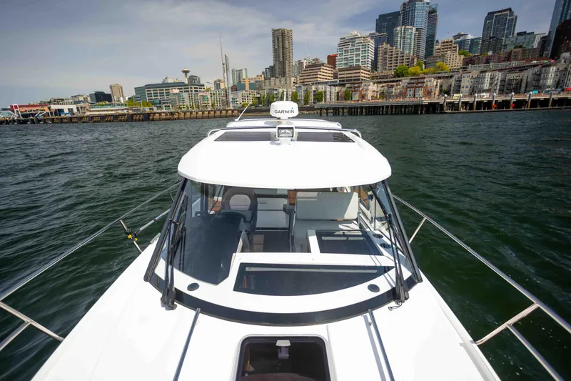 Slide: The Image of 2022 Jeanneau NC Weekender 895 on water with city skyline in background. - 4