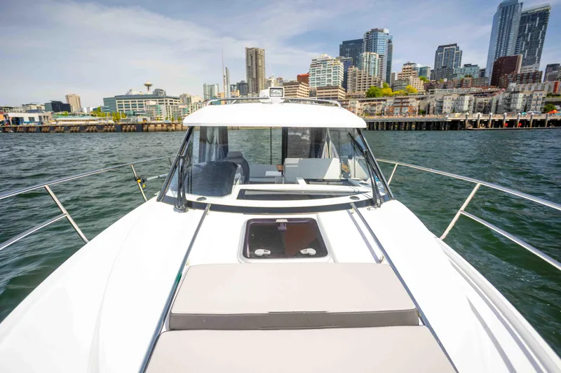 Slide: The Image of 2022 Jeanneau NC Weekender 895 on water with city skyline in background. - 5