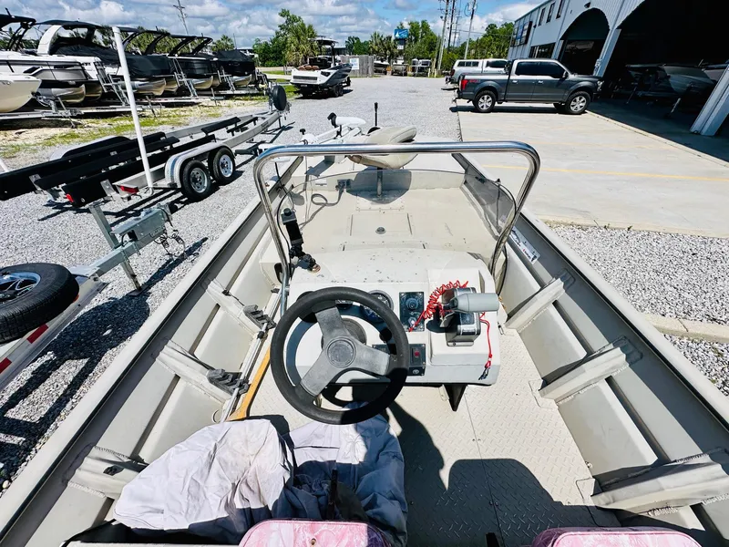 Slide: The Image of 2008 SeaArk x160 boat interior with steering wheel, parked in a lot with trailers and vehicles. - 10