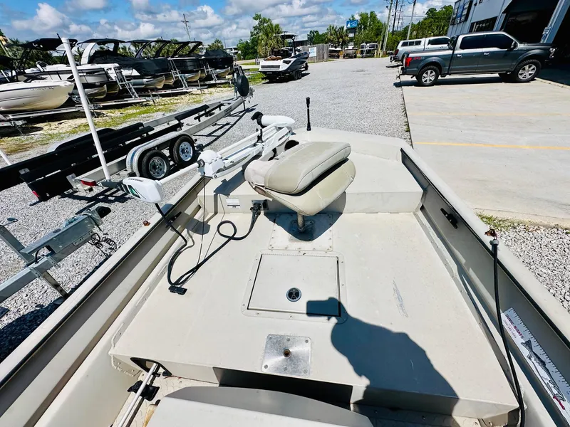 Slide: The Image of 2008 SeaArk x160 boat interior with seat and equipment, parked near trailers and vehicles. - 11