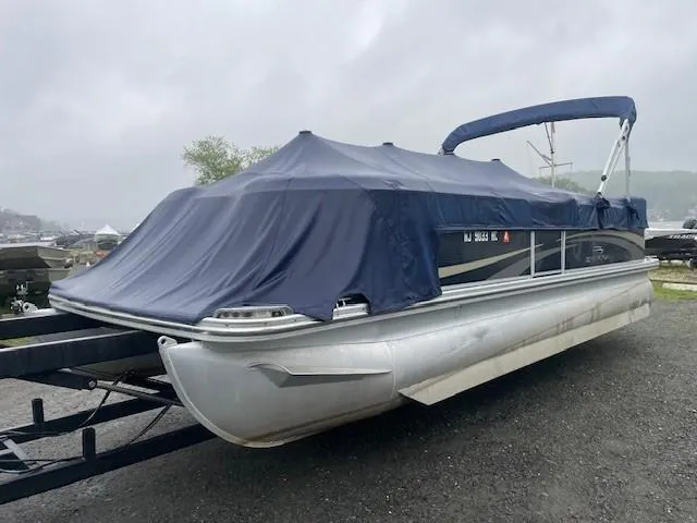 Slide: The Image of 2011 Bennington 2275GLi pontoon boat with blue cover on a trailer. - 1