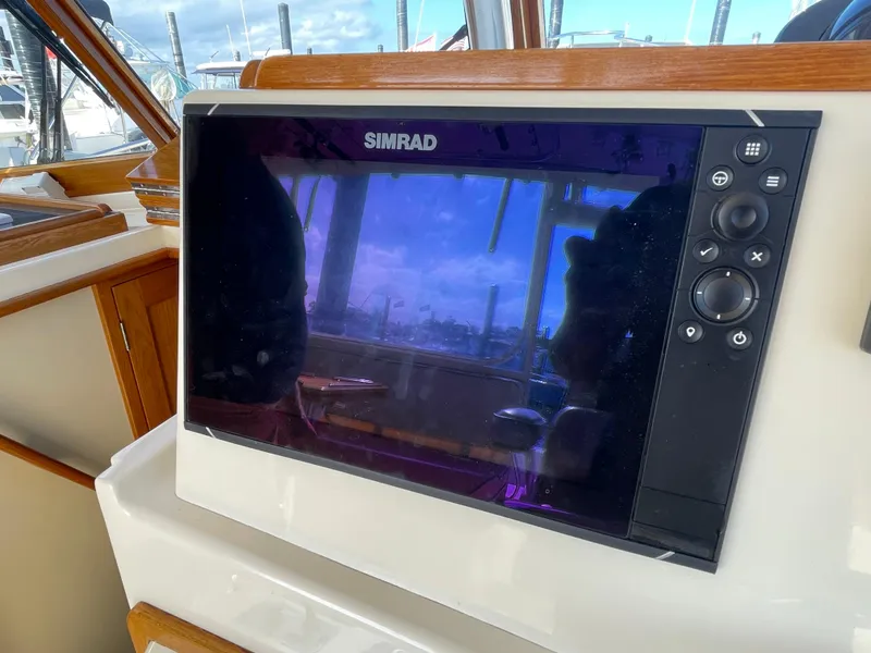 Slide: The Image of Simrad navigation system on 2015 Fortier 30 boat dashboard, reflecting marina view. - 11