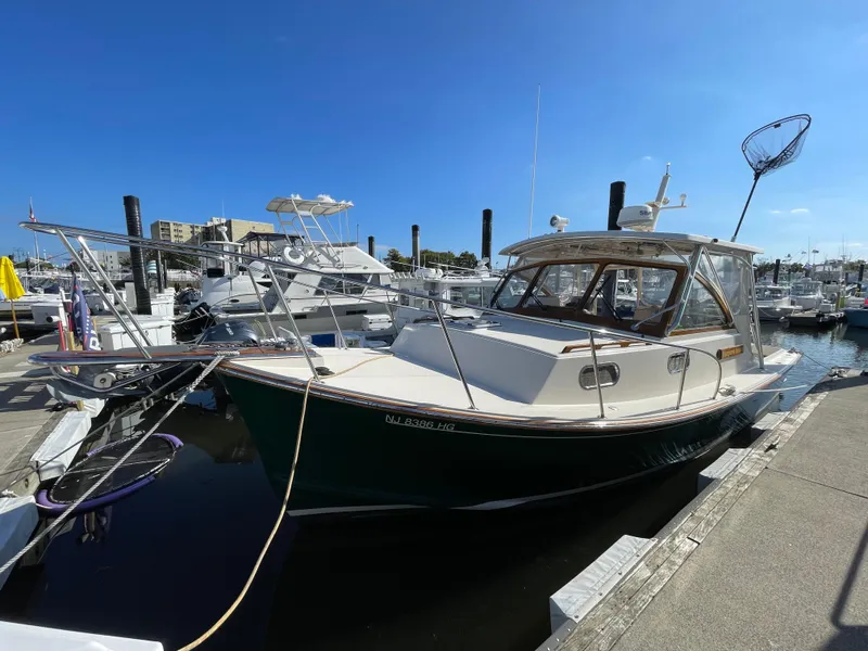 Slide: The Image of 2015 Fortier 30 boat docked at a marina under clear blue skies. - 2