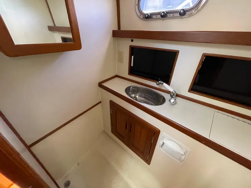Slide: The Image of Compact bathroom in a 2015 Fortier 30 boat with sink and wooden accents. - 23
