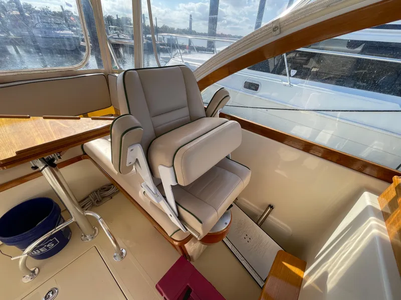 Slide: The Image of Captain's chair on 2015 Fortier 30 boat, featuring beige upholstery and wooden accents. - 7