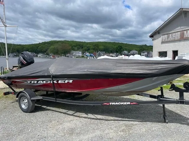 Slide: The Image of 2023 Tracker Pro Team 175 TXW boat covered on trailer, parked near marina. - 15