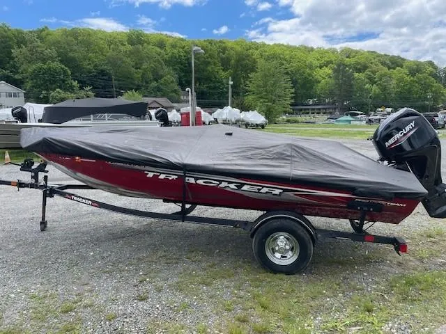 Slide: The Image of 2023 Tracker Pro Team 175 TXW boat covered, on trailer, outdoors with trees in background. - 16