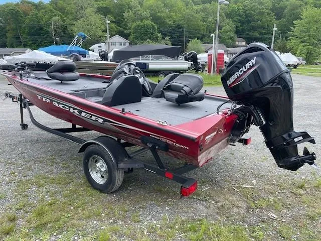 Slide: The Image of 2023 Tracker Pro Team 175 TXW boat with Mercury engine, parked outdoors. - 2