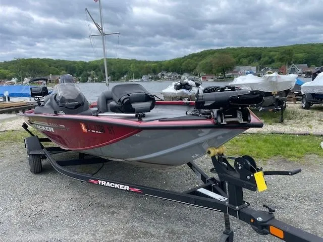 Slide: The Image of 2023 Tracker Pro Team 175 TXW boat on trailer by a lake under cloudy skies. - 7