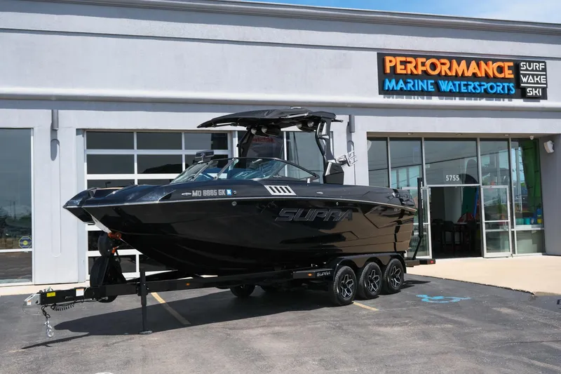 Slide: The Image of 2019 Supra SE450 boat on trailer outside Performance Marine Watersports store. - 1