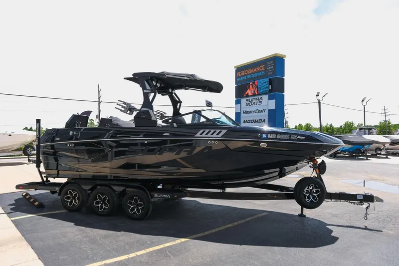 Slide: The Image of 2019 Supra SE450 boat on trailer at dealership parking lot. - 13