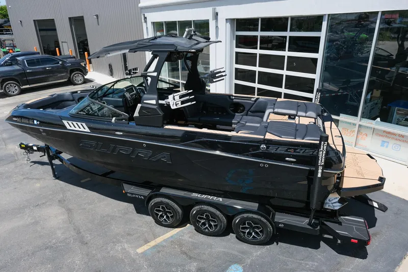 Slide: The Image of 2019 Supra SE450 boat on trailer, parked outside a modern building. - 6