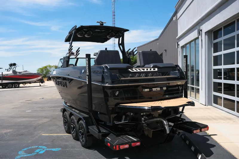 Slide: The Image of 2019 Supra SE450 boat on trailer, parked outside a building under clear blue sky. - 8