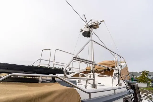 Slide: The Image of 2015 Ranger Tugs R-31 CB boat with radar and railing, docked under cloudy skies. - 10