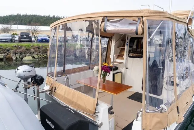 Slide: The Image of 2015 Ranger Tugs R-31 CB boat with enclosed cockpit and Honda outboard motor. - 2