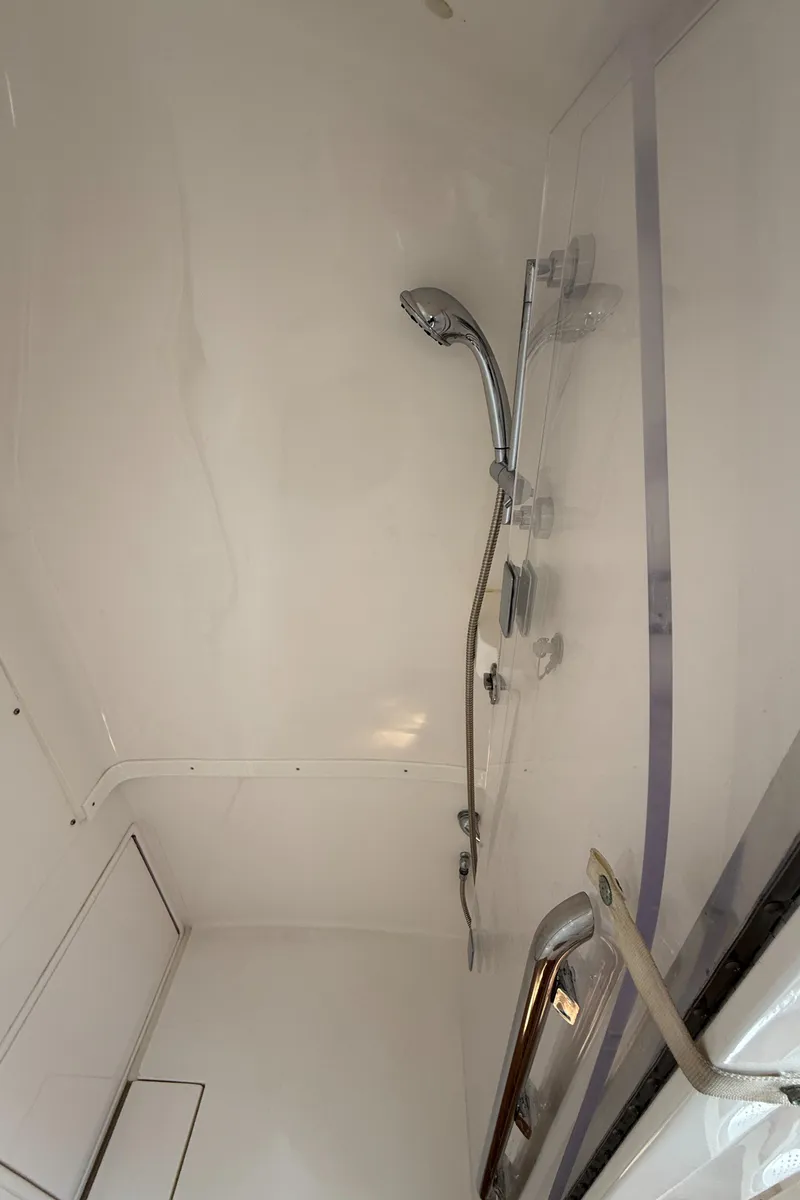 Slide: The Image of 2015 Intrepid 375 Walkaround boat shower interior with chrome fixtures. - 10