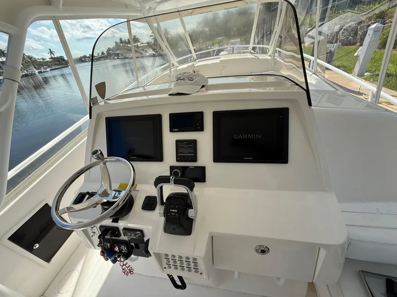 Slide: The Image of 2015 Intrepid 375 Walkaround helm with Garmin displays and steering wheel, docked by water. - 12