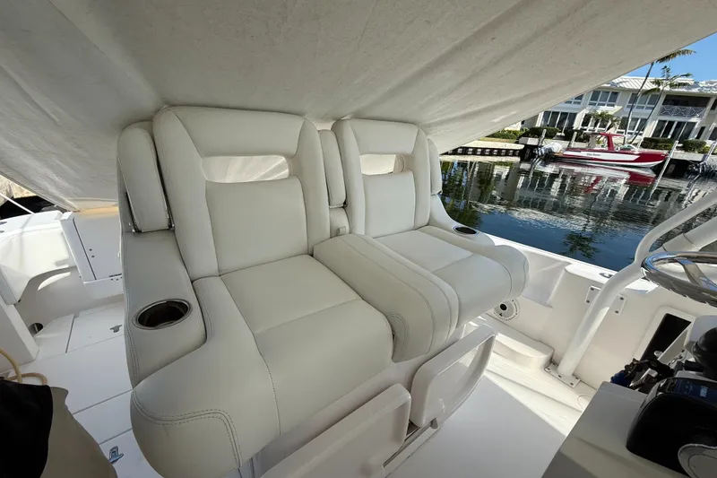 Slide: The Image of Luxurious seating on a 2015 Intrepid 375 Walkaround boat, docked by waterfront homes. - 16