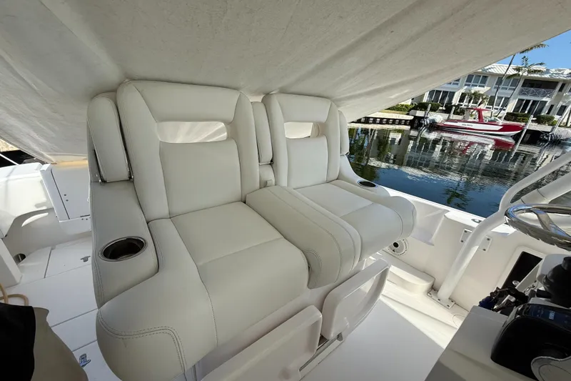 Slide: The Image of 2015 Intrepid 375 Walkaround boat with plush white seating and cup holders. - 17