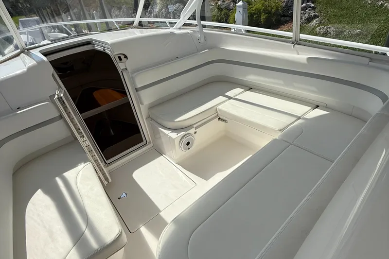 Slide: The Image of 2015 Intrepid 375 Walkaround boat interior with white seating and open cabin door. - 20