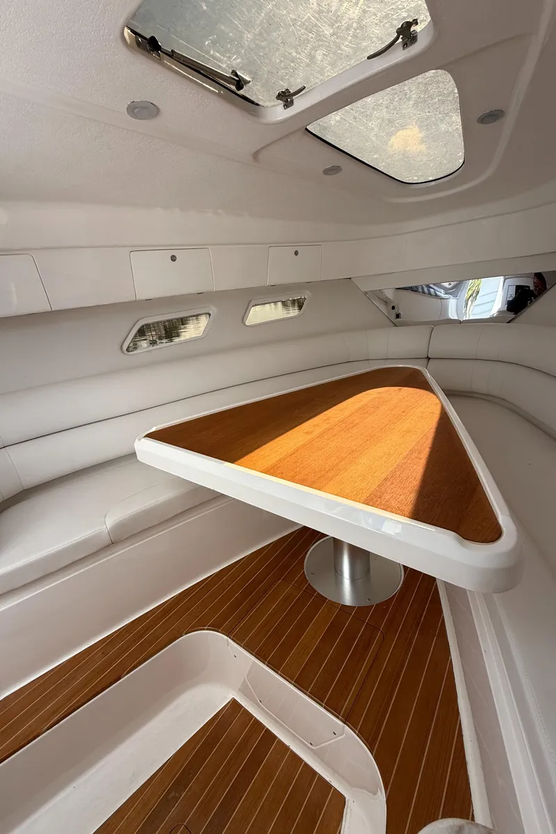 Slide: The Image of 2015 Intrepid 375 Walkaround cabin interior with wooden table and seating. - 7