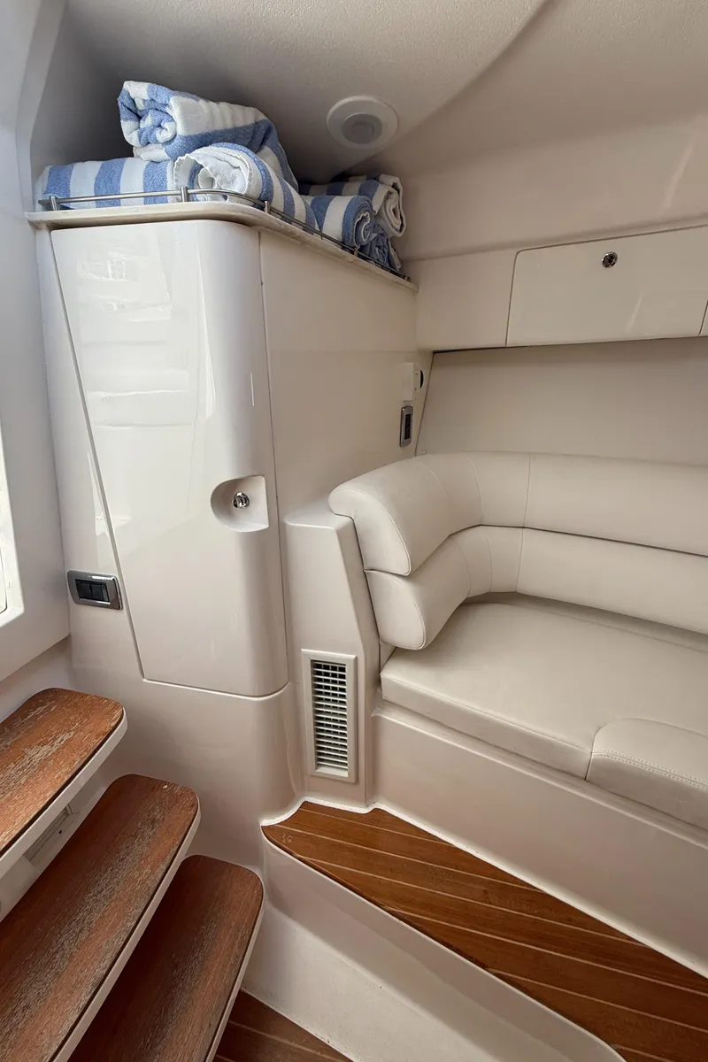 Slide: The Image of 2015 Intrepid 375 Walkaround cabin interior with seating and wooden steps. - 8