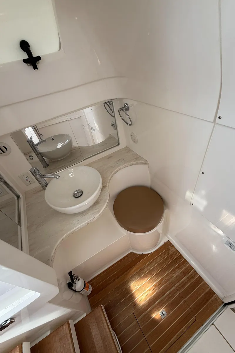 Slide: The Image of 2015 Intrepid 375 Walkaround boat bathroom with sink, mirror, and wooden flooring. - 9