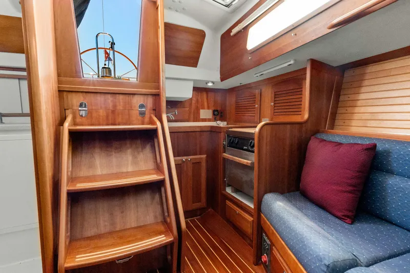 Slide: The Image of 2008 Sabre Spirit yacht interior with wooden cabinetry, stairs, and cozy seating area. - 16
