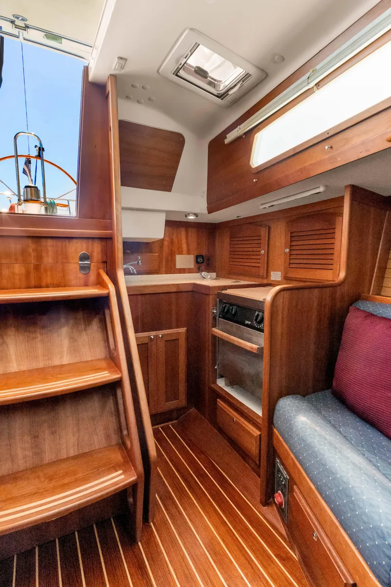 Slide: The Image of 2008 Sabre Spirit yacht interior with wooden cabinetry, stairs, and seating area. - 17