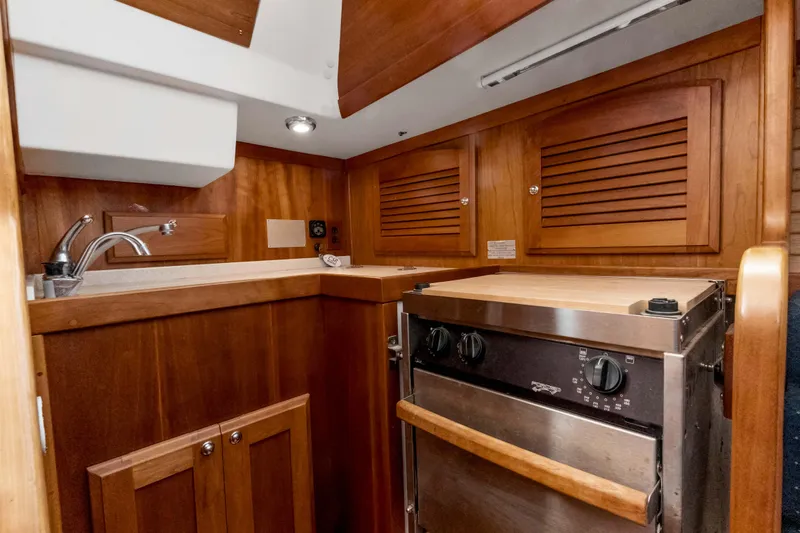 Slide: The Image of 2008 Sabre Spirit yacht interior with wooden cabinetry and stainless steel stove. - 26